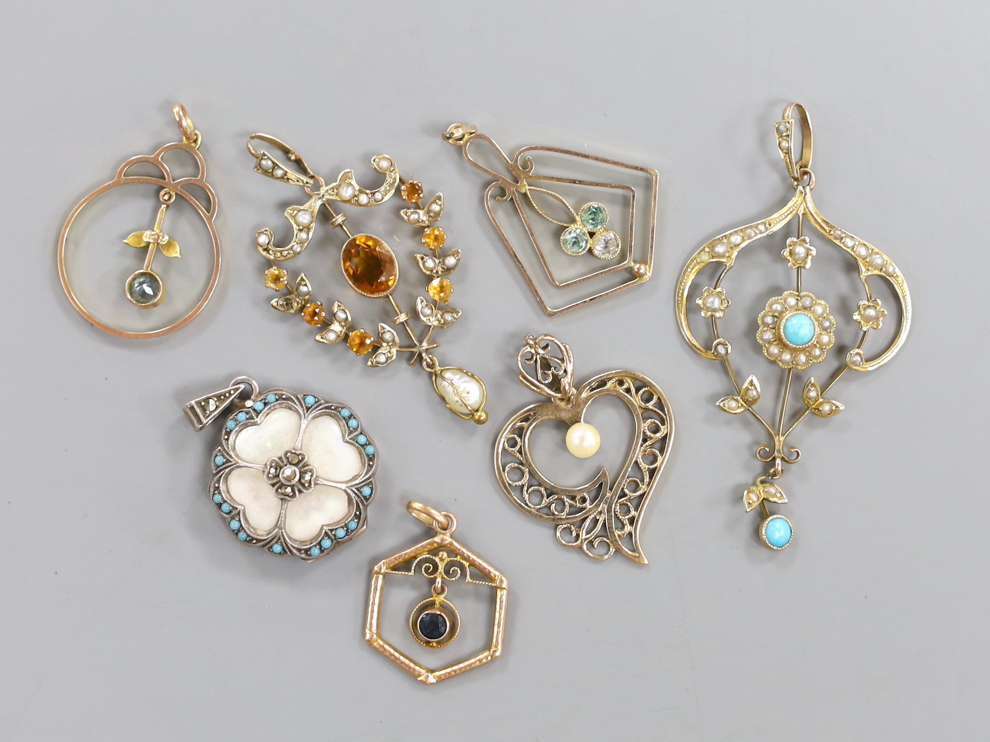 Seven assorted mainly early 20th century pendants, including 9ct, seed pearl and turquoise, white metal, marcasite and mother of pearl and a 9ct citrine and seed pearl.